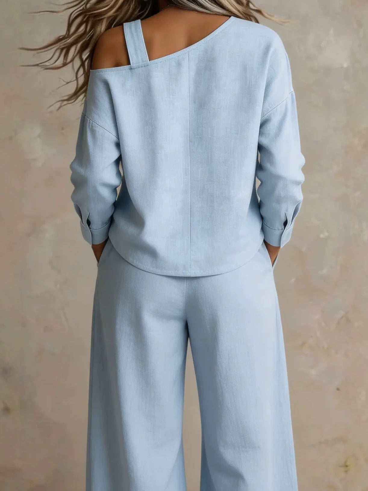 Woman wearing one-shoulder linen top and matching pants